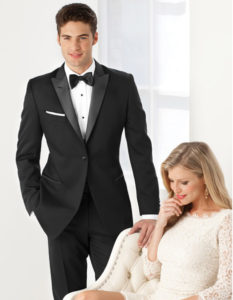 Man in black tuxedo with woman.