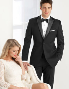Man in tuxedo with woman in white dress.