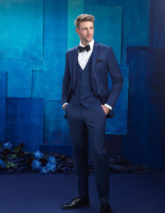 Man in navy blue tuxedo and bow tie.