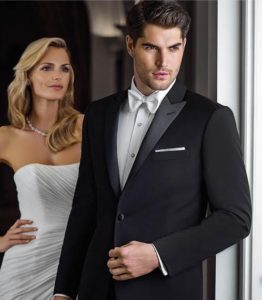 Groom in tuxedo with bride in white dress.