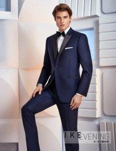 Here's an alt tag for the image: Man in navy blue tuxedo.