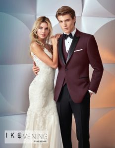 Couple in wedding attire; burgundy tuxedo.