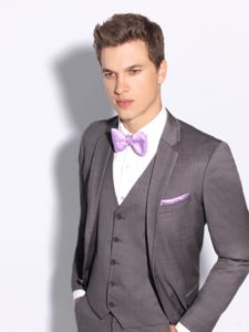 Man in gray suit with purple bow tie.