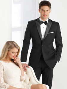 Man in tuxedo with woman in white dress.