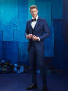 Man in blue tuxedo against blue background.