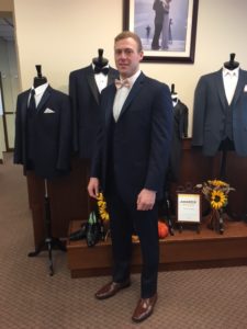 Man in navy suit, light pink tie.