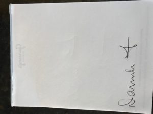 White paper with cross and signature.