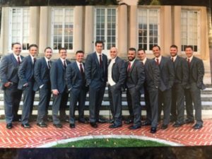 Twelve groomsmen in gray suits, red ties.