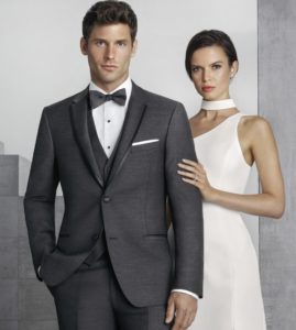 Man in gray tuxedo with woman in white dress.