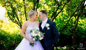 Bride and groom embracing outdoors.