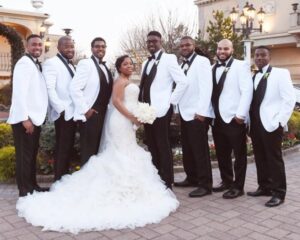 Bride and groomsmen in white tuxedos.