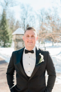 Smiling groom in tuxedo, winter wedding.