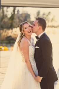 Happy bride and groom kissing outdoors.