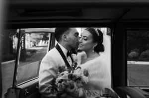 Bride and groom kissing in a car.